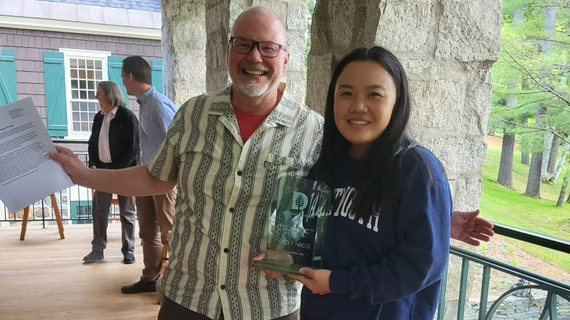 Gerol Fang holds plaque and smiles next to Department Chair Chris Sneddon