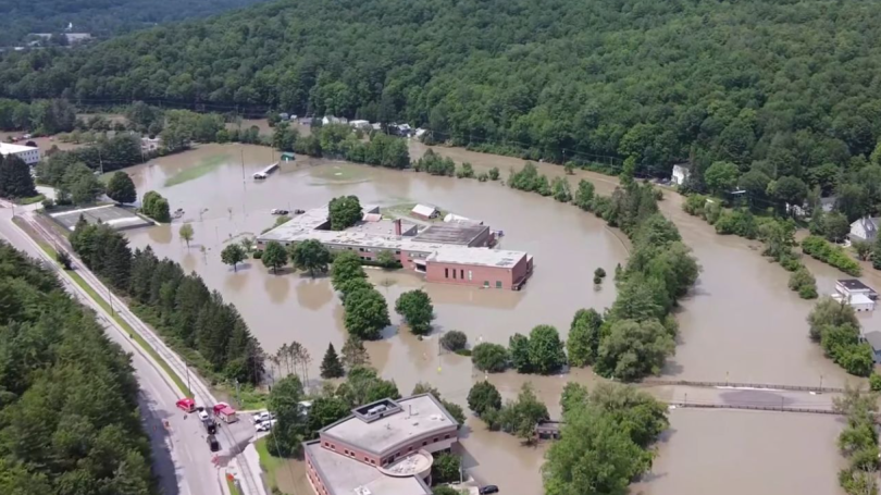 Aerial image of Vermont flood from above. Many brick buildings are completely surrounded by water. 